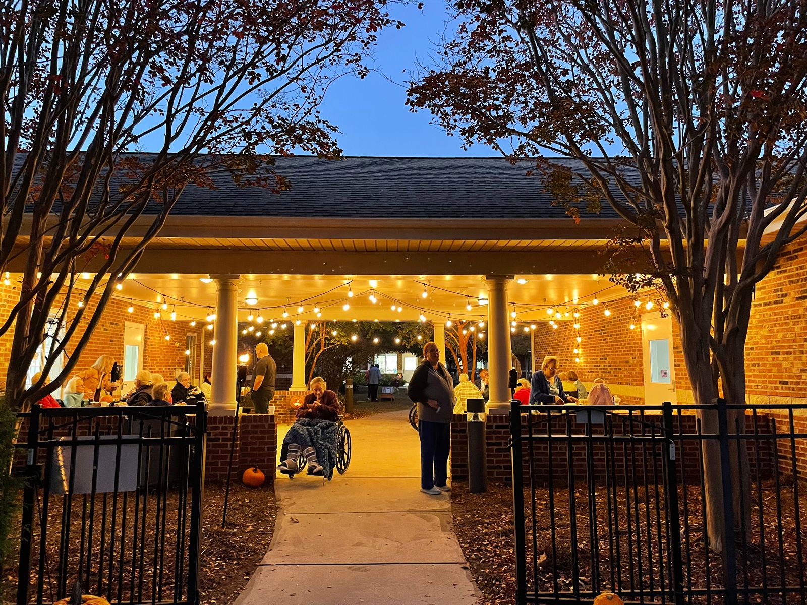 The pavilion glowing under string lights at dusk